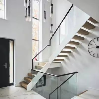 Moderne scale diritte interne scala galleggiante in ferro e acciaio con battistrada di legno e ringhiera di vetro per commercio e appartamento